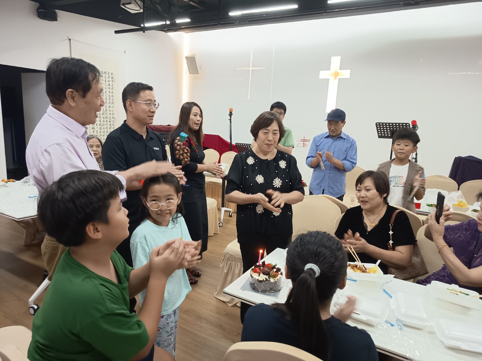九月生日庆祝中弟兄姊妹围着蛋糕送上祝福